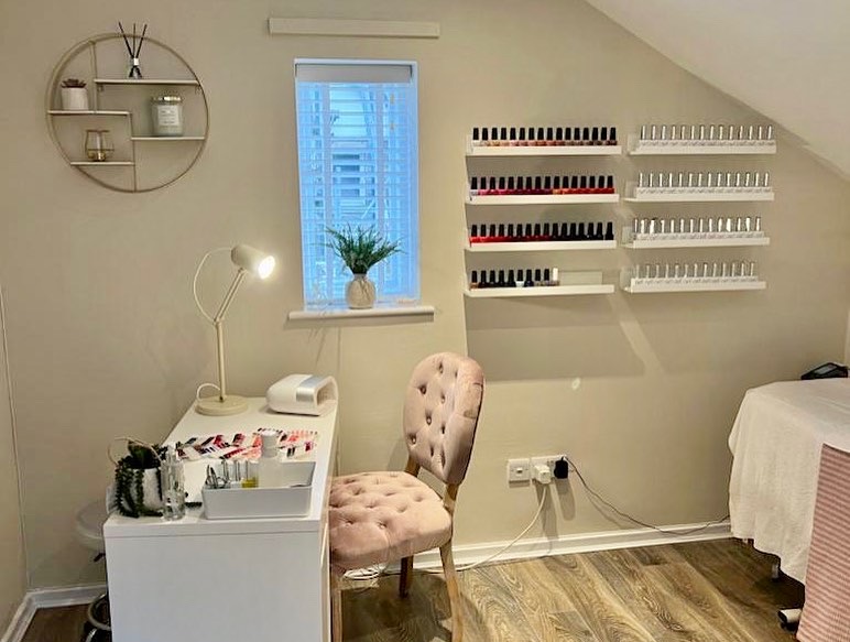 A blush upholstered manicure chair and neatly arranged nail colours at Fresh